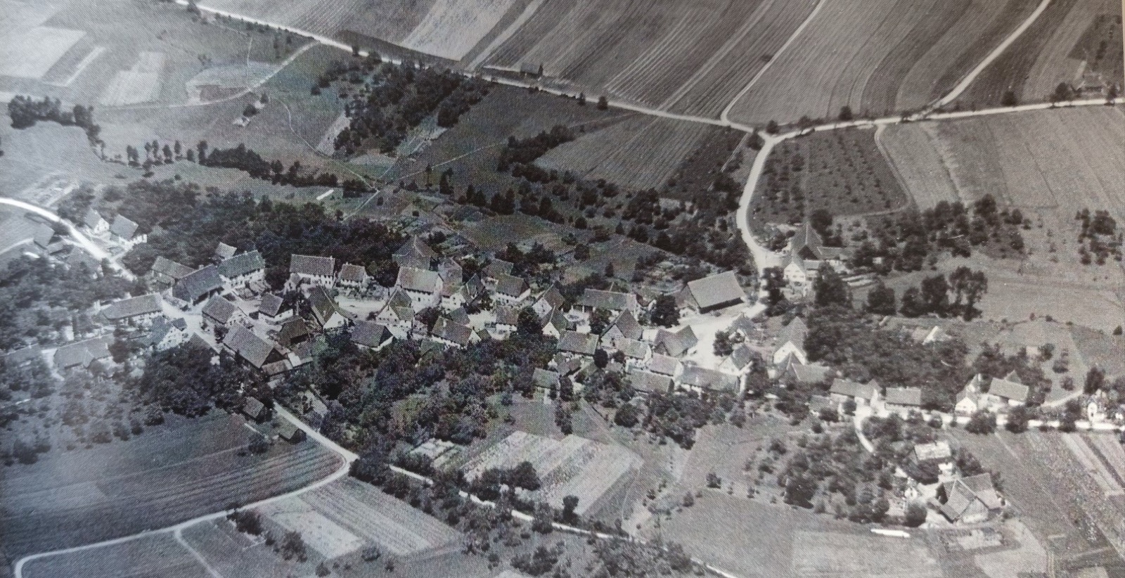 Historisches Schwarz-Weiß-Luftbild von Sanzenbach mit Häusern, Obstbäumen und Feldern