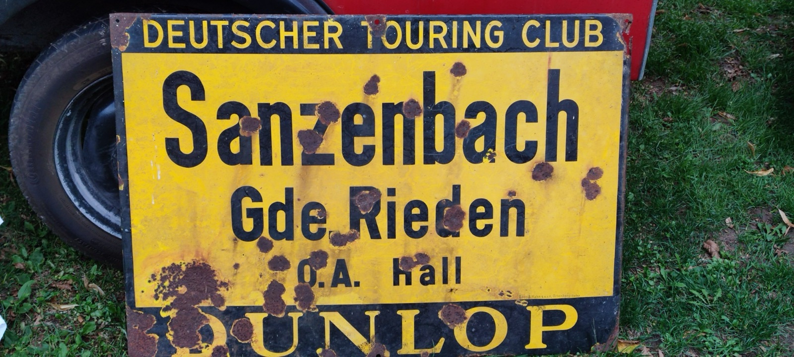 Gelbes Emailschild des Deutschen Touring Clubs mit der Aufschrift Sanzenbach, Gde. Rieden, O.A. Hall und Dunlop-Werbung
