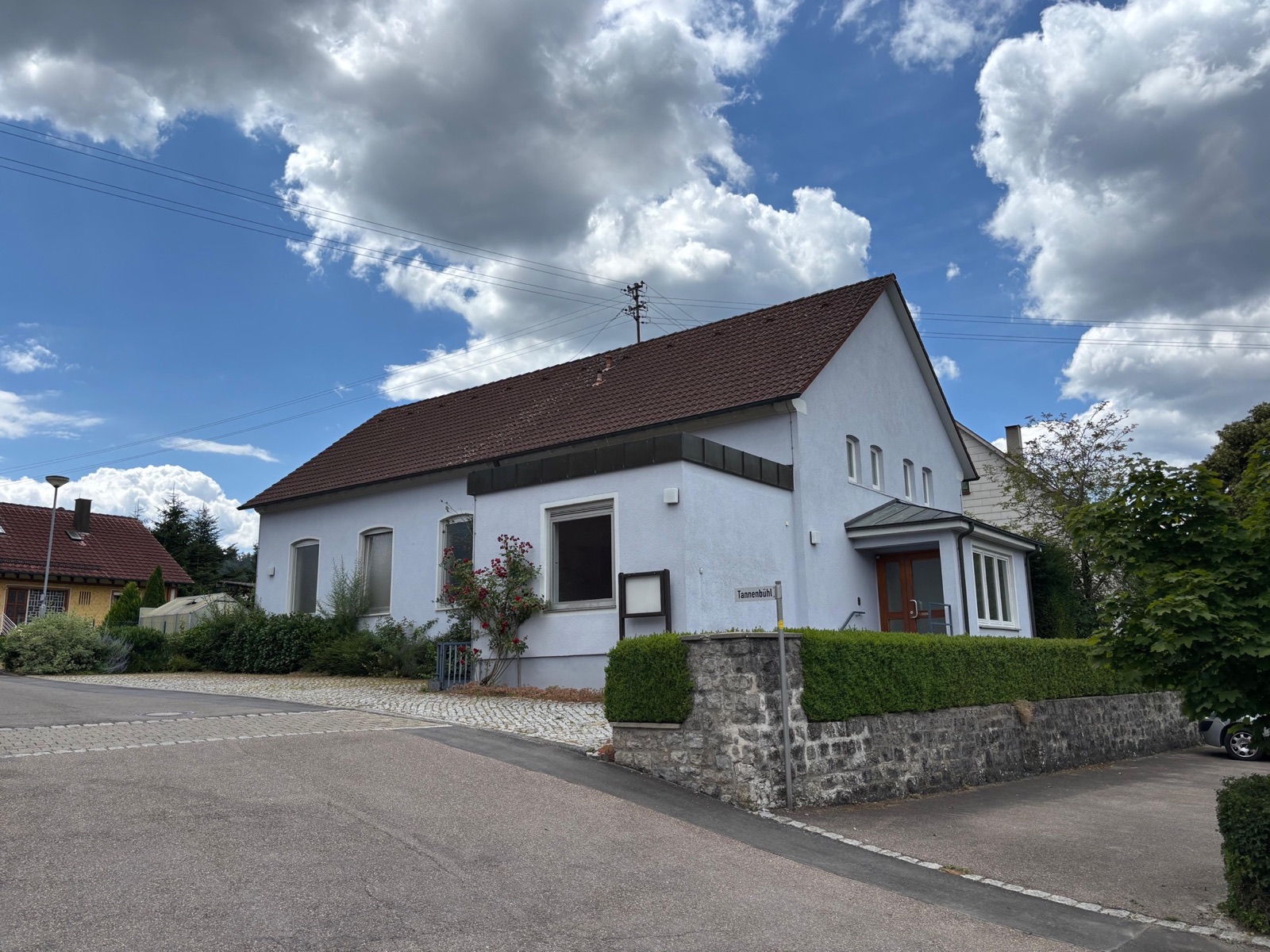 Das Dorfgemeinschaftshaus Sanzenbach mit hellem Putz und rotem Ziegeldach
