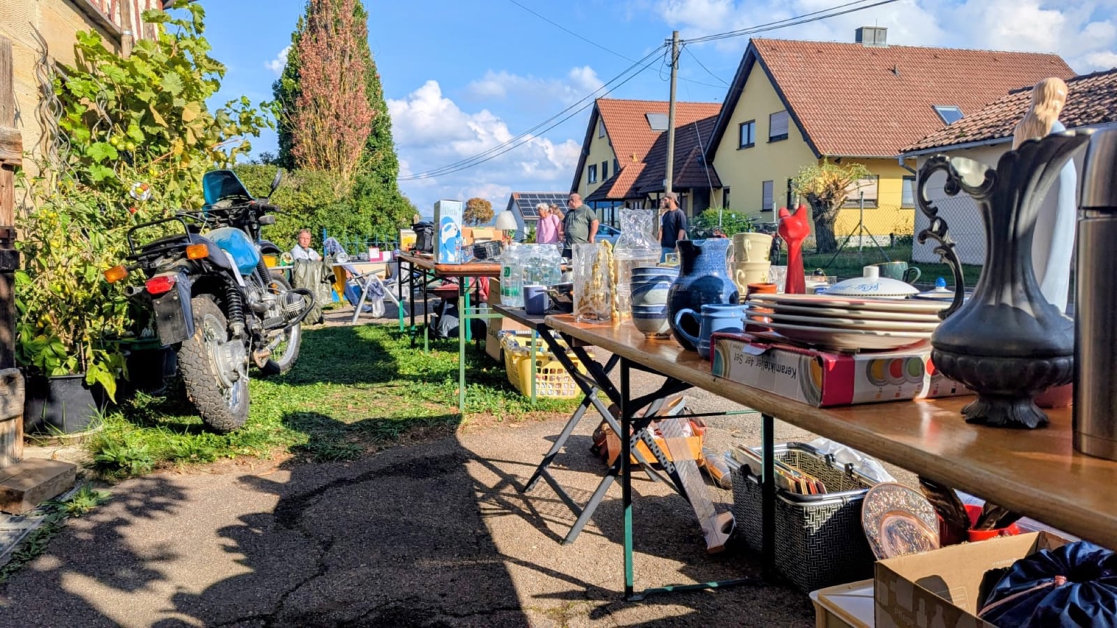 Verkaufstische mit Geschirr und Krügen vor den Häusern